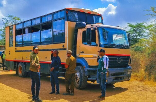 African Affarble Expeditions Overland Mobile Camping Safari Truck Preparation Affarble Overland mobile camping safari truck with guides preparing for departure in a sunny savannah setting.