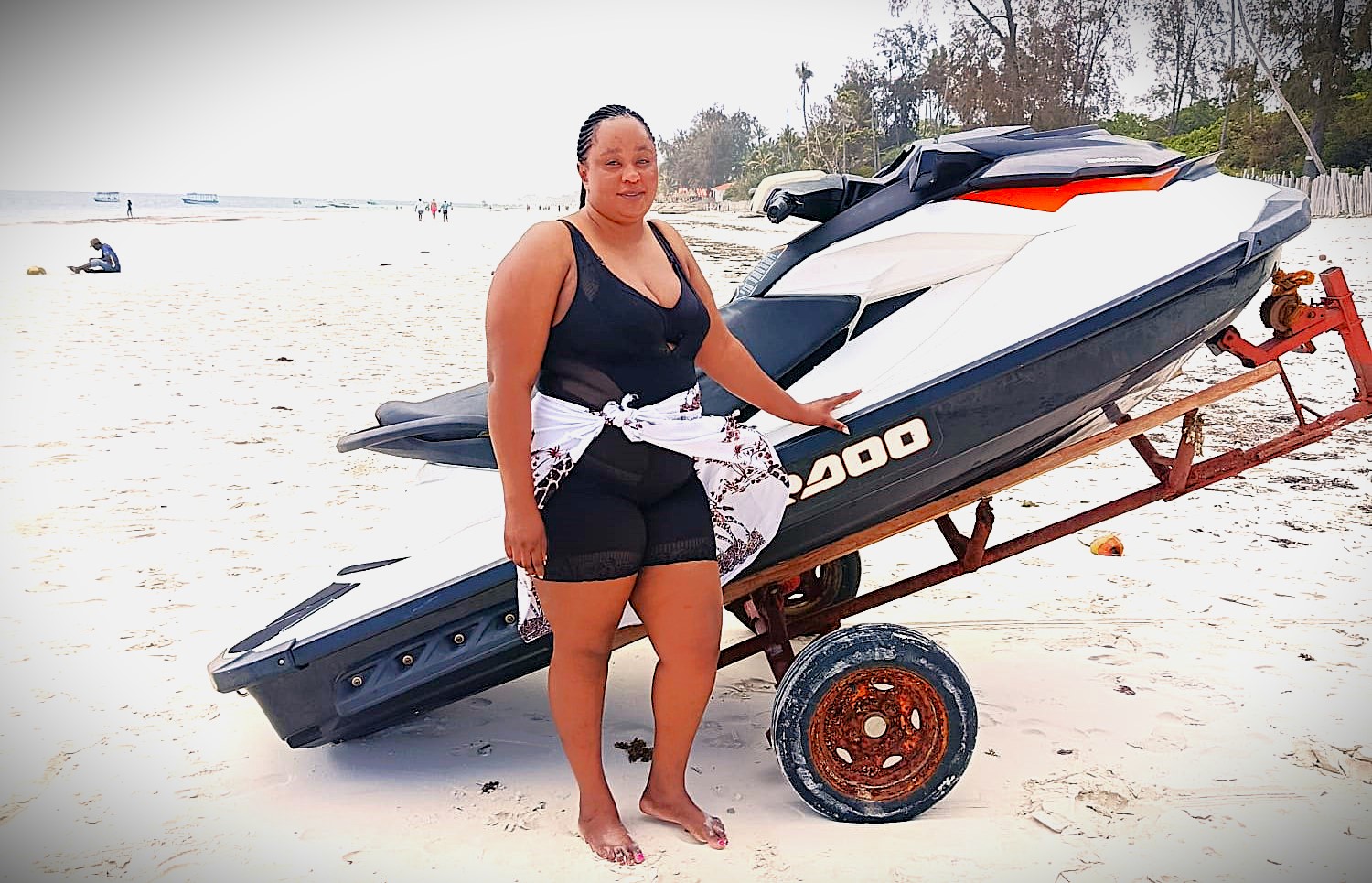 Beach Speed Boat Experience – 8-Day Luxury Honeymoon Safari & Beach Holiday Lady standing beside a speed boat on a sandy beach during an 8-Day Luxury Honeymoon Safari & Beach Holiday in Kenya